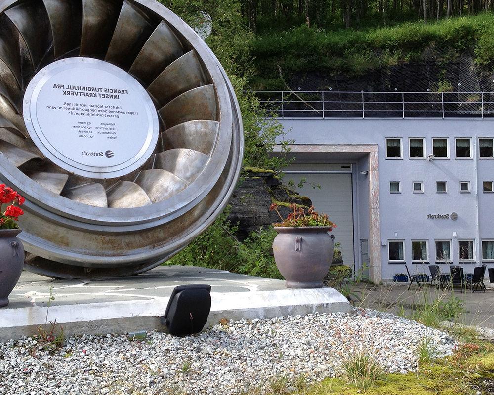 Innsett power plant reception building with turbine wheel and anniversary plaque. 
