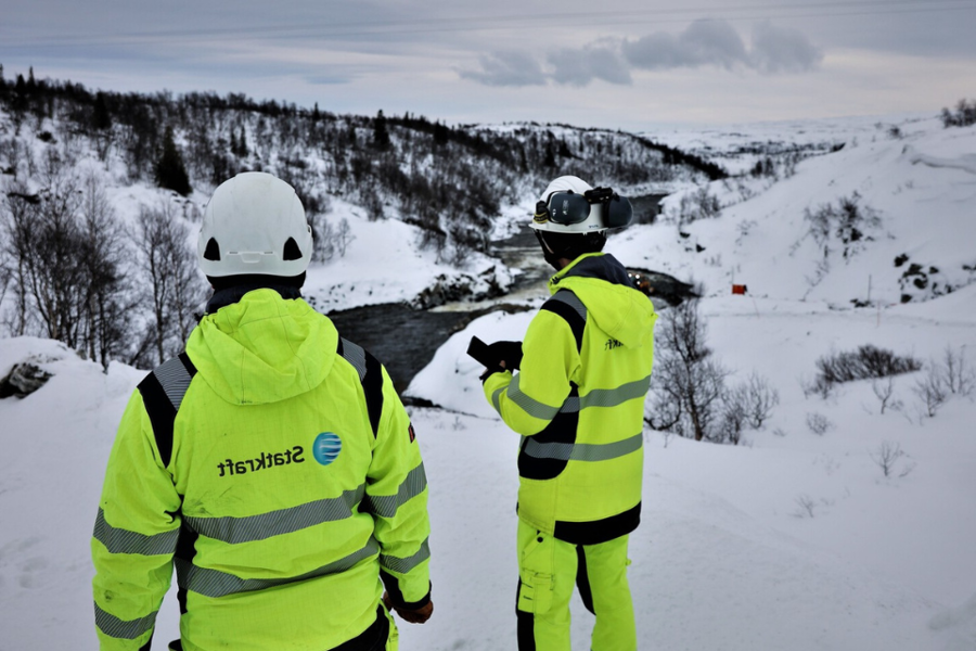 Two colleagues wearing safety gear on top of a hill above the Nesjø dam